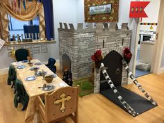 a table set up for a party with castle decorations on the walls and around it