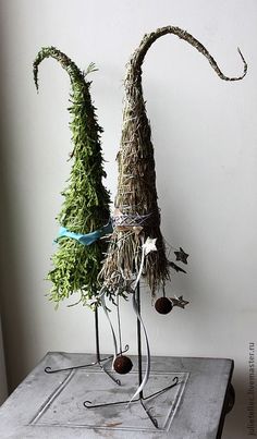 two sculptures made out of branches and pine cones