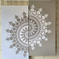 two canvass with white and grey designs on them, one is made from paper