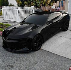 a black sports car parked in front of a house