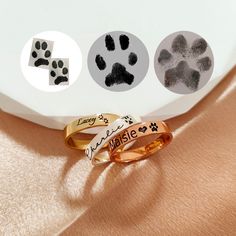 three rings with different designs on them sitting next to each other and one has paw prints