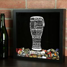 a beer bottle and some bottles on a shelf next to a brick wall with a black frame