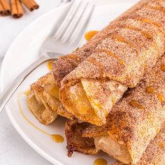 some food is on a white plate with a fork next to it and cinnamon sprinkles