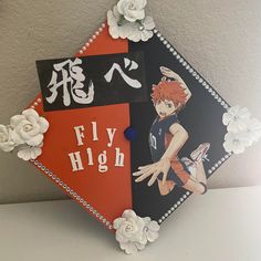 a decorated graduation cap with an anime character on the front and flowers in the back