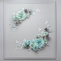 paper flowers are arranged in the shape of an o on a white background with silver frame