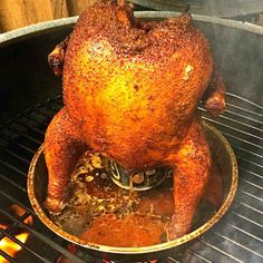 a roasting chicken is being cooked on the grill