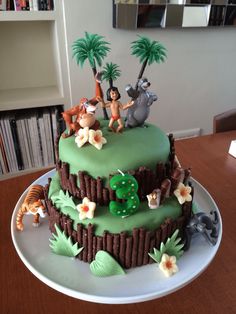 a birthday cake decorated with jungle animals and palm trees