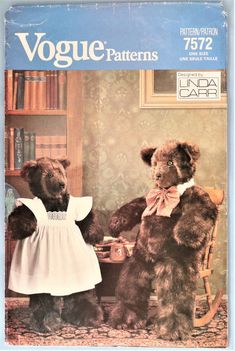 two teddy bears dressed in white dress standing next to each other near a bookcase