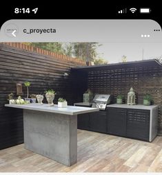 an outdoor kitchen is shown on the phone screen, and there are potted plants next to it