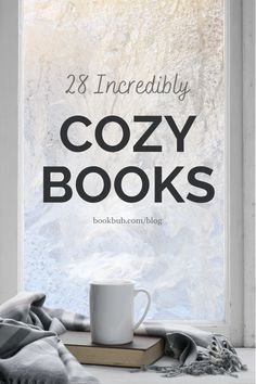 a coffee cup sitting on top of a book next to a window with the title 28 incredibly cozy books