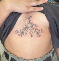 a close up of a person's stomach with flowers on it and the bottom part of her belly