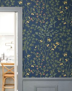 an open door leading to a kitchen with blue wallpaper and yellow flowers on it