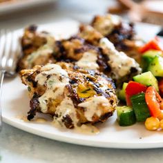 a white plate topped with chicken and veggies