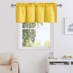 a living room with a white couch and yellow valance on the window sill