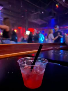 a drink sitting on top of a table next to a glass with a straw in it