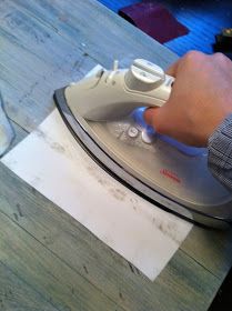 a person using an iron on top of a wooden table