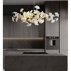 a modern chandelier hanging over a kitchen island with an oven and microwave in the background