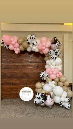 the balloon arch is decorated with cow balloons and pink, white, and black balloons