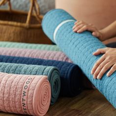 a woman is laying on the floor with her yoga mat and towel rolled up next to it