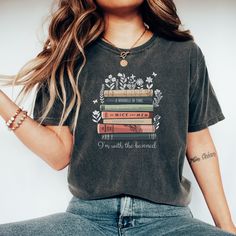 "Celebrate the power of literature and take a stand for intellectual freedom with our \"I'm With The Banned\" Comfort Colors t-shirt. Featuring a row of famous and popular vintage banned books and the punny phrase \"I'm With The Banned,\" this unique design is perfect for book lovers, literature enthusiasts, and anyone who champions the freedom to read. Made from high-quality Comfort Colors fabric, this unisex t-shirt offers a soft, comfortable fit that's ideal for casual outings, book clubs, or showing support for the right to read whatever you choose. The bold design and clever message make it a fun and conversation-starting addition to any wardrobe. The \"I'm With The Banned\" Comfort Colors t-shirt is a fantastic gift for friends, family, or yourself, and it's sure to be a hit among fe Screen Print Crew Neck T-shirt, Cotton Slogan T-shirt, Library T Shirts, The Book Was Better Shirt, Read Banned Books Shirt, Banned Books Tshirt, I Read Banned Books, Banned Books Shirt, Literary Crew Neck T-shirt With Screen Print