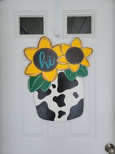 a door with a cow and sunflowers painted on the front part of it