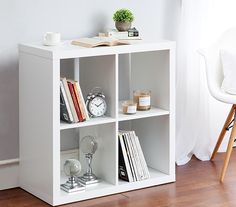 a white book shelf with books and magazines on it