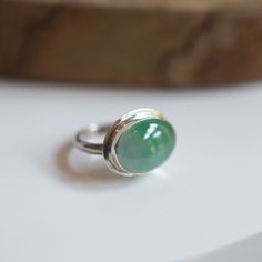 This is the perfect East-West Oval Ring and this Burma Jade is so special - there's nothing quite like it! The 12X16mm stone rests perfectly in this east-west oval configuration. Simple and perfect with just an edge of .925 Sterling Silver. Wear this Green Jade Statement Ring alone or on a handful of rings.  All traditional silversmithing is done in my Baltimore, MD studio. Burma Jade - 12X16mm oval Ring top measures 14X18mm 925 Sterling Silver Jade is a symbol of serenity, tranquility, and purity. It's a stone that's believed to bring good luck, friendship, peace, and harmony. A protective stone because of its abilities to ward off negative energies. At Linda Blackbourn Jewelry, we've tried our best to describe everything as accurately as possible -- in words and photos. Gemstones vary, o Green Oval Moonstone Gemstone Ring, Green Oval Moonstone Ring, Oval Green Moonstone Gemstone Ring, Green Sterling Silver Oval Rings, Green Oval Sterling Silver Rings, Silver Polished Oval Cabochon Emerald Ring, Polished Chrysoprase Ring Jewelry, Silver Emerald Ring With Polished Oval Cabochon, Green Polished Sterling Silver Gemstones