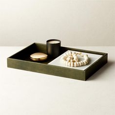 a tray with some food on it and a cup next to it, sitting on a table