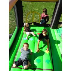 three children are playing on an inflatable slide