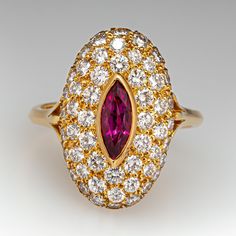 This elegant ring is centered with one (1), bezel set, marquise mixed cut natural ruby. The ruby is bordered with fifty-two (52), bead set, round brilliant cut diamonds. The ring has a reverse tapered "knife edge" style shank. The ring measures 19.5mm at the top, rises 7.7mm above the finger, tapering to 2.7mm wide and 1.6mm thick at the base of the shank. This ring is currently a size 6.75. The ring shows a lovely soft patina. Luxury Marquise Ruby Ring With Diamonds, Luxury Marquise Red Ruby Ring, Luxury Red Marquise Ruby Ring, Luxury Ruby Marquise Cut Rings, Luxury Ruby Ring Marquise Cut For Formal Events, Luxury Ruby Marquise Cut Ring For Formal Occasions, Luxury Marquise Cut Ruby Ring For Formal Occasions, Luxury Yellow Gold Ruby Ring With Marquise Cut, Luxury Marquise Cut Yellow Gold Ruby Ring