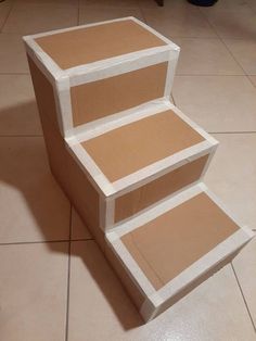 three cardboard steps sitting on top of each other in the middle of a tile floor