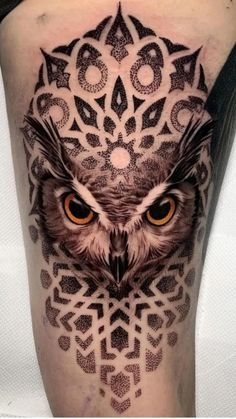 an owl tattoo on the leg with geometric shapes and circles around its eyes is shown