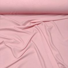 a pink sheet that is laying on top of a bed