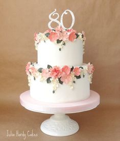 a white cake with pink flowers and the number 80 on top