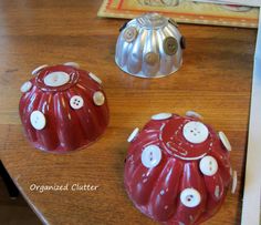 two red and white ceramic objects on a table with buttons in the shape of bundts