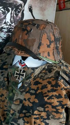 an army uniform is displayed on a mannequin's head with a poster in the background