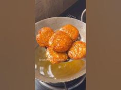 some food is being cooked in a frying pan on the stove top with sauce