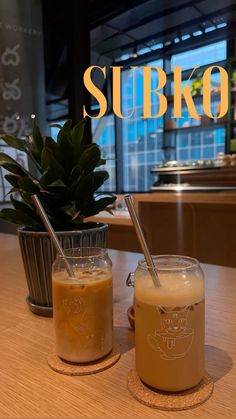 two drinks sitting on top of a wooden table