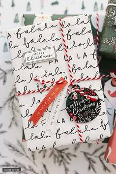 two wrapped presents sitting next to each other on top of snow covered ground with christmas wrapping around them