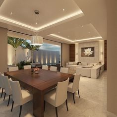 a dining room table with white chairs and a large window overlooking the ocean at night