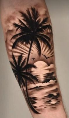 a man's arm with a sunset and palm tree tattoo on it