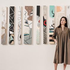 a woman standing in front of some art pieces