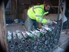 a man in yellow jacket and safety gear working on bottles