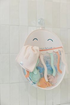 a bath room with a toilet and a towel hanging from the wall next to a tiled wall