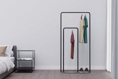 a clothes rack in the corner of a bedroom next to a bed