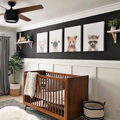 a baby's room with pictures on the wall and a crib next to it