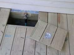 an open hole in the side of a wooden deck with a small stuffed animal inside