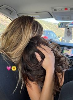 a woman sitting in the back seat of a car with her head resting on her hands