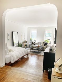 a bedroom with hardwood floors and white walls