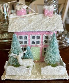 a small doll house with deer and snow on the roof